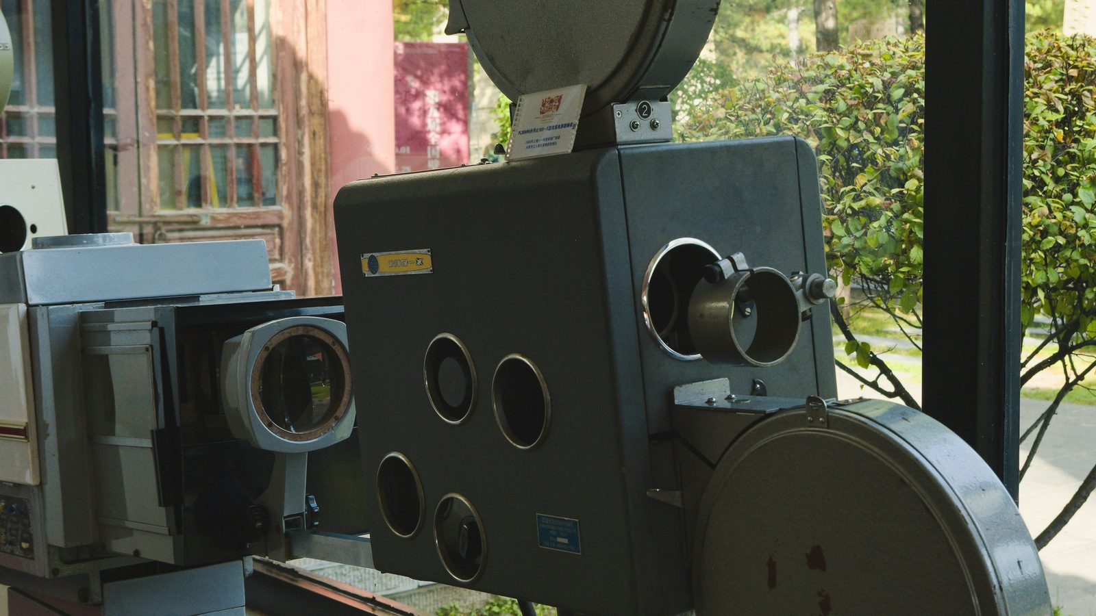 Ancien projecteur de cinéma exposé près d’une fenêtre