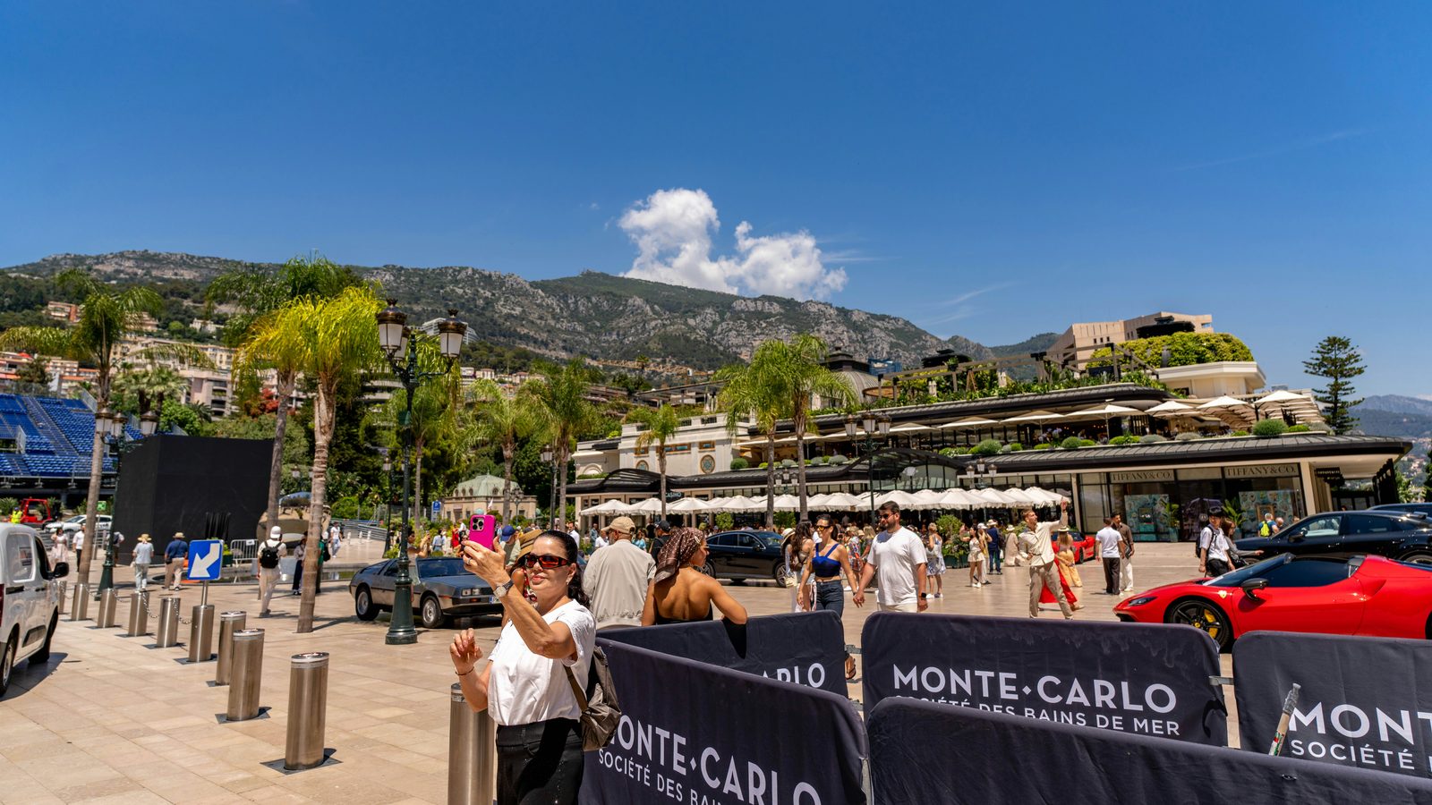Place animée de Monte-Carlo sous le ciel bleu avec palmiers